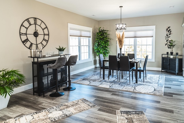 dining space with a chandelier, baseboards, and wood finished floors