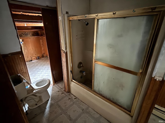 bathroom with combined bath / shower with glass door, a baseboard radiator, and toilet