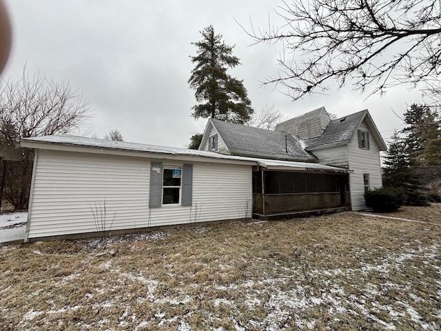 view of home's exterior with a sunroom
