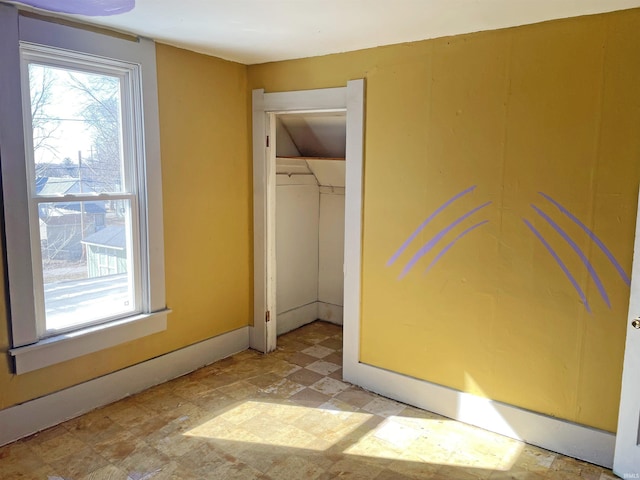 unfurnished bedroom with a closet, multiple windows, baseboards, and light floors