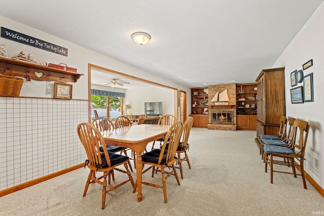 760 Ln 136 Turkey Lk, Hudson, IN 46747 - dining room with a textured ceiling, built in features, a fireplace, wainscoting, and light colored carpet