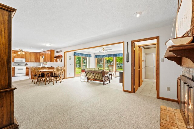 760 Ln 136 Turkey Lk, Hudson, IN 46747 - living room featuring light carpet, a textured ceiling, ceiling fan, and a fireplace