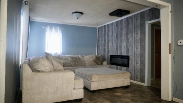 living room featuring baseboards, a fireplace, and crown molding