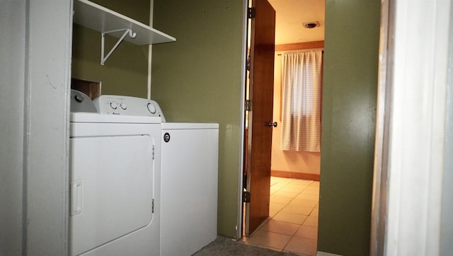 clothes washing area with washer and dryer, baseboards, laundry area, and tile patterned floors