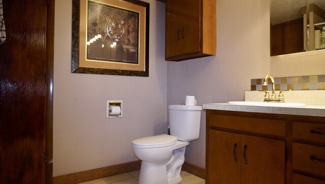 bathroom with backsplash, baseboards, toilet, tile patterned floors, and vanity