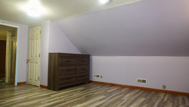additional living space featuring visible vents, baseboards, and wood finished floors