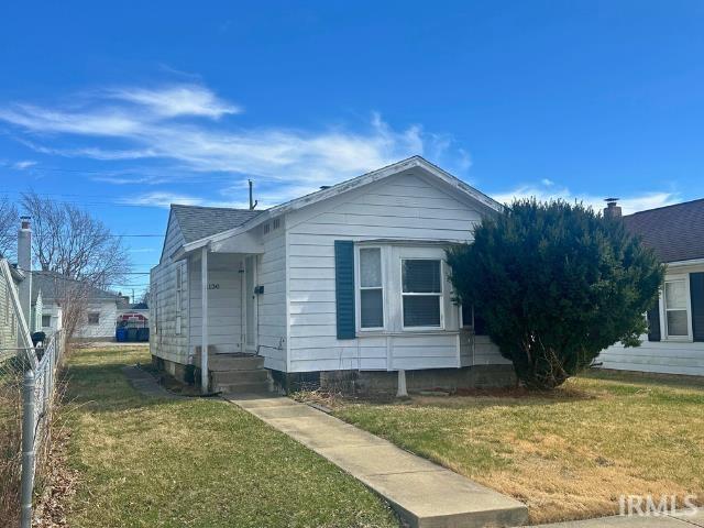 1130 N Lindsay St, Kokomo, IN 46902 - bungalow-style house with a shingled roof, a front yard, and fence