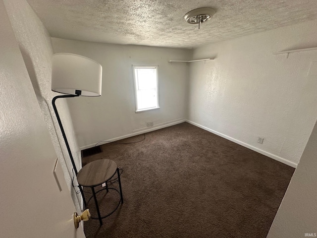 1130 N Lindsay St, Kokomo, IN 46902 - interior space with baseboards, a textured ceiling, a textured wall, and dark colored carpet
