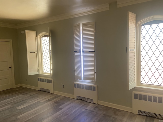 foyer with wood finished floors, radiator heating unit, and crown molding
