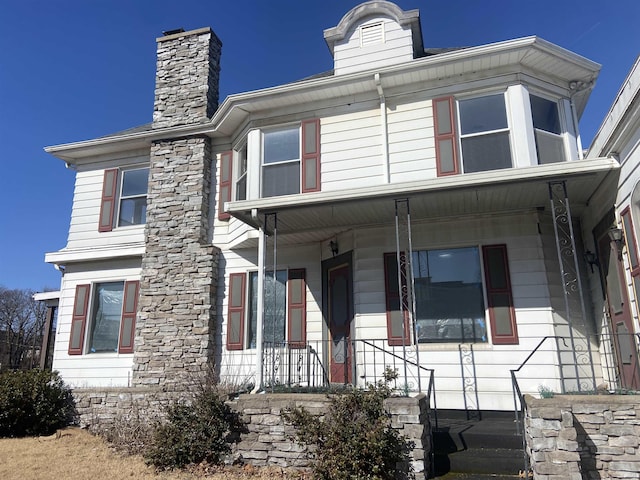 view of front of house with a chimney and a porch
