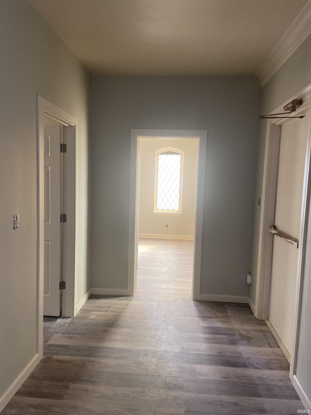 corridor with baseboards and wood finished floors