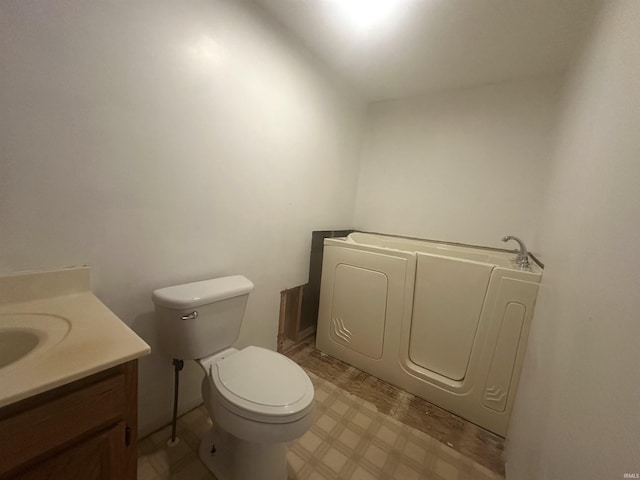 bathroom with tile patterned floors, toilet, a bath, and vanity