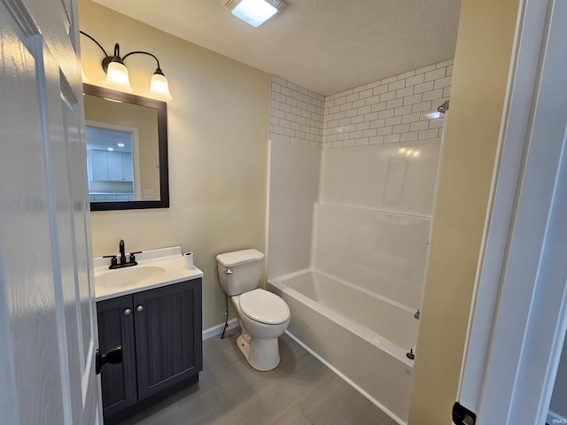 full bath featuring wood finished floors, a textured ceiling, vanity, baseboards, and toilet