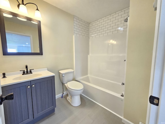 full bathroom featuring baseboards, toilet, vanity, and shower / washtub combination