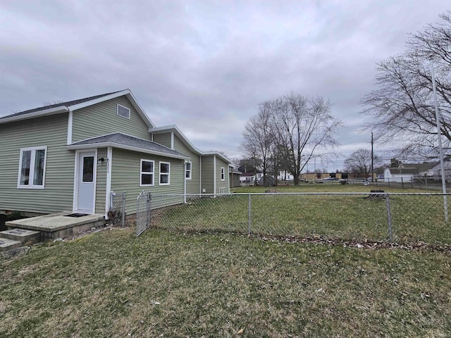 view of property exterior featuring a lawn and fence