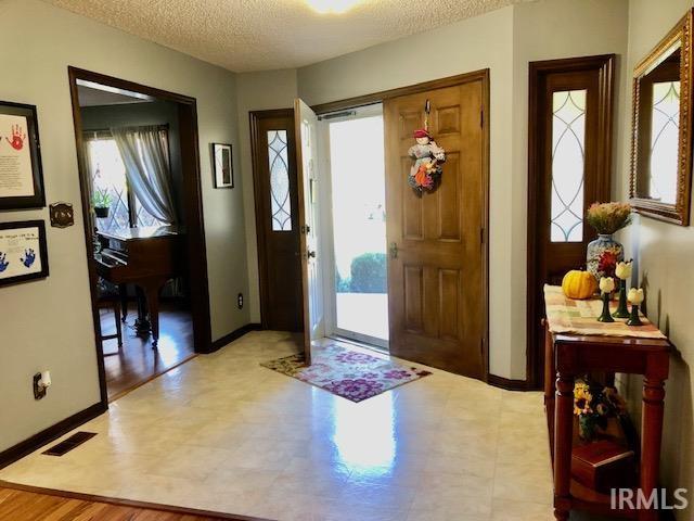 9420 Darmstadt Rd, Evansville, IN 47710 - entryway featuring a wealth of natural light, visible vents, a textured ceiling, and baseboards