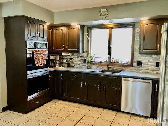 9420 Darmstadt Rd, Evansville, IN 47710 - kitchen featuring a sink, light tile patterned floors, tasteful backsplash, and stainless steel appliances