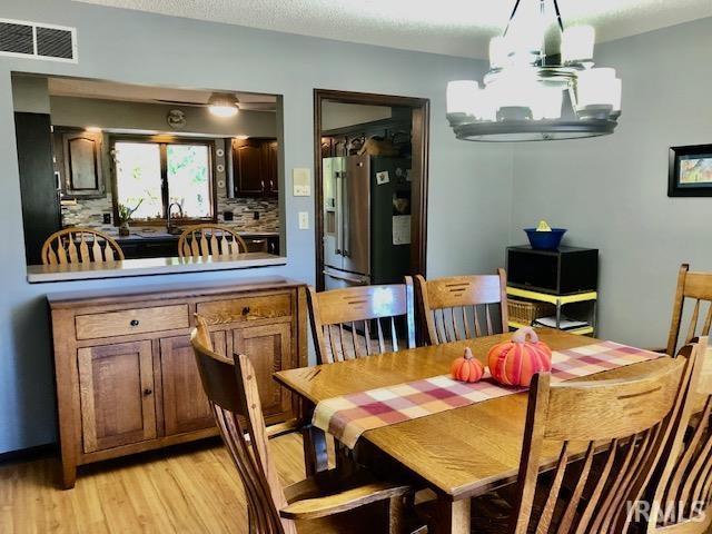 9420 Darmstadt Rd, Evansville, IN 47710 - dining room with a notable chandelier, visible vents, and light wood-style floors
