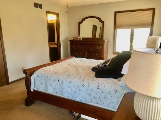 9420 Darmstadt Rd, Evansville, IN 47710 - bedroom featuring visible vents, connected bathroom, baseboards, and carpet