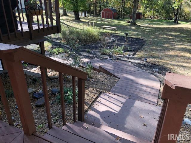 9420 Darmstadt Rd, Evansville, IN 47710 - wooden terrace featuring a storage shed, an outbuilding, and a lawn