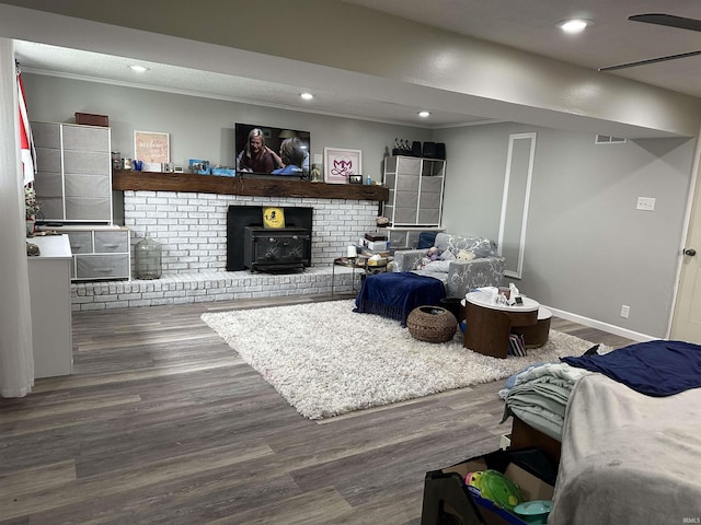 living room featuring wood finished floors, baseboards, ornamental molding, visible vents, and recessed lighting
