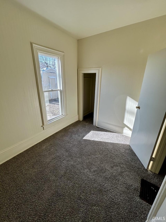 carpeted spare room with baseboards