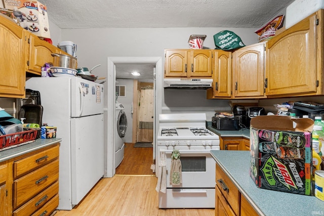 kitchen featuring under cabinet range hood, light wood-style flooring, white appliances, and a textured ceiling