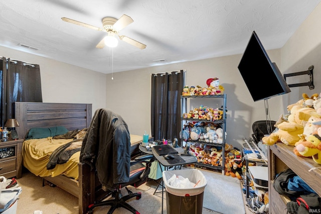 carpeted bedroom featuring a textured ceiling, visible vents, and ceiling fan