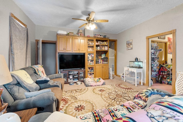 living room featuring light carpet, visible vents, a textured ceiling, and a ceiling fan