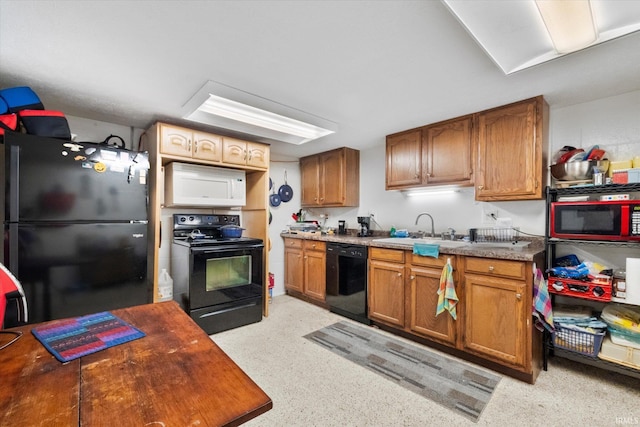kitchen featuring black appliances, brown cabinets, and a sink