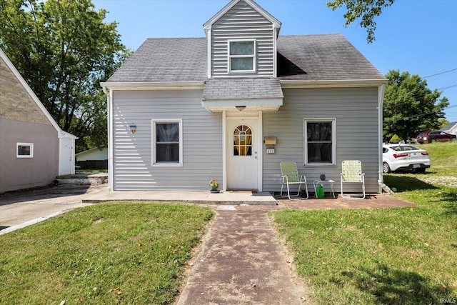 view of front of property with a front yard and a shingled roof