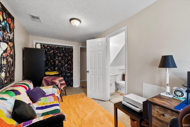 bedroom with a closet, visible vents, and a textured ceiling
