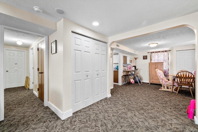 interior space featuring visible vents, baseboards, carpet floors, and a textured ceiling