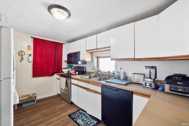 kitchen with black appliances, a sink, wood finished floors, white cabinets, and light countertops
