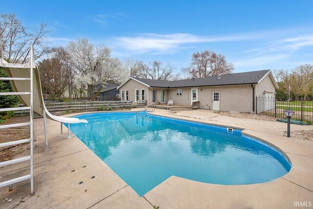 view of pool featuring a fenced in pool, a water slide, a patio, and fence