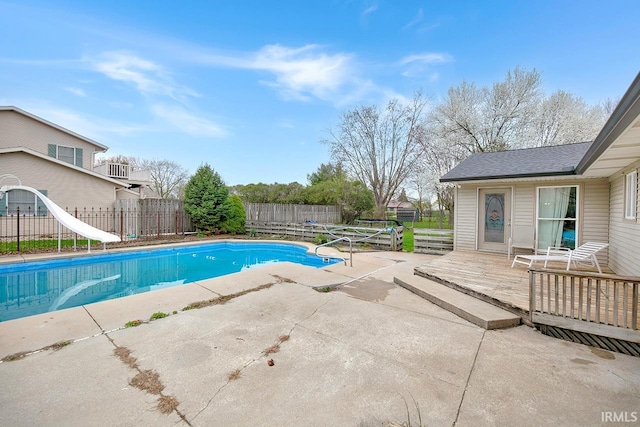 view of swimming pool featuring a patio area, a fenced backyard, a water slide, and a fenced in pool