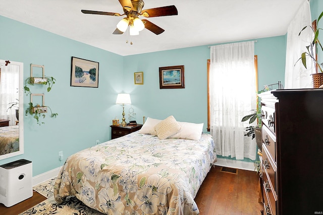 bedroom featuring a ceiling fan, baseboards, and wood finished floors