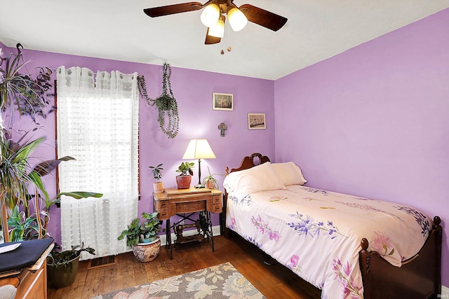 bedroom with baseboards, visible vents, wood finished floors, and ceiling fan