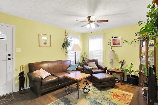 living room with hardwood / wood-style floors, a ceiling fan, and baseboards