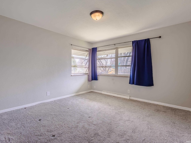 carpeted empty room with a baseboard radiator and baseboards