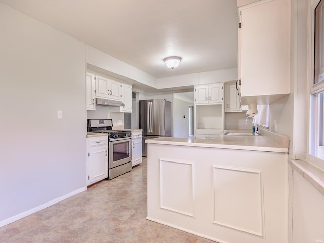 kitchen with a peninsula, white cabinets, under cabinet range hood, appliances with stainless steel finishes, and a sink