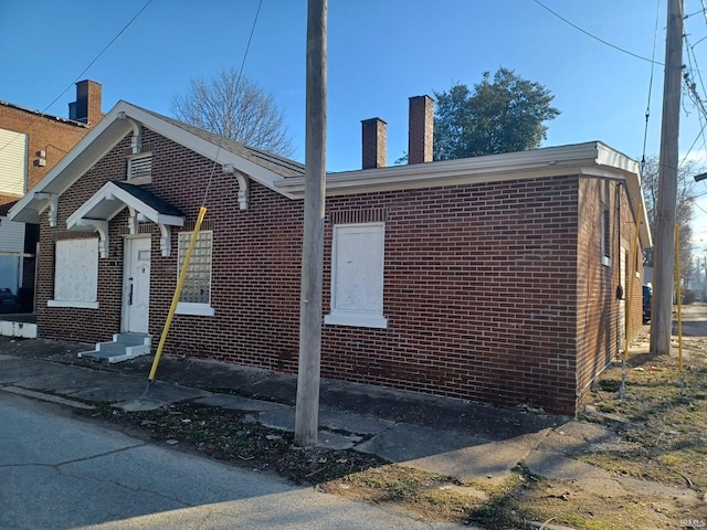 807 Washington Ave, Evansville, IN 47714 - view of home's exterior with a chimney, entry steps, and brick siding