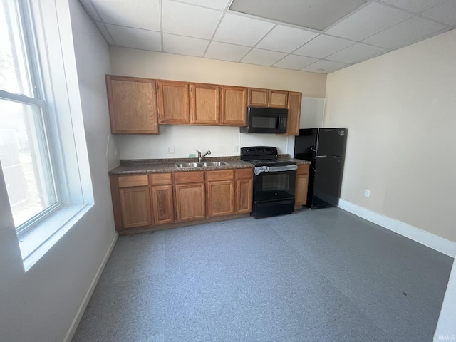 807 Washington Ave, Evansville, IN 47714 - kitchen with baseboards, dark countertops, light floors, a sink, and black appliances