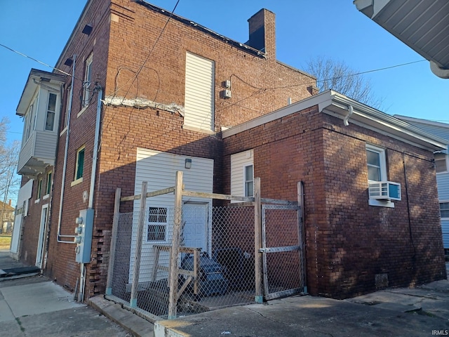 807 Washington Ave, Evansville, IN 47714 - rear view of house with a gate, fence, a chimney, brick siding, and cooling unit