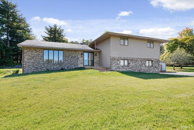 tri-level home with a front yard and stone siding