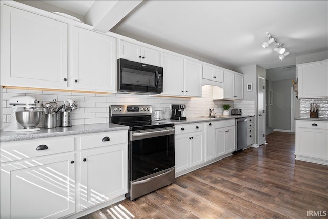 kitchen with dark wood-style flooring, white cabinets, stainless steel appliances, a sink, and backsplash