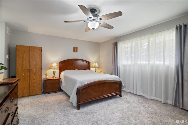 bedroom with ceiling fan, visible vents, and light colored carpet