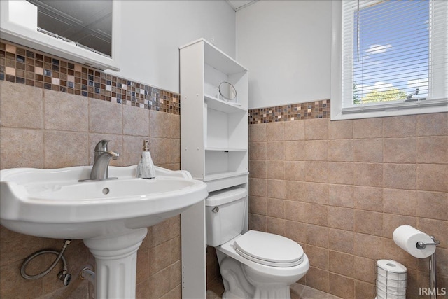 bathroom featuring toilet and tile walls