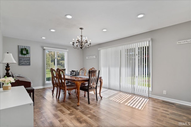 dining space featuring baseboards, wood finished floors, and a chandelier