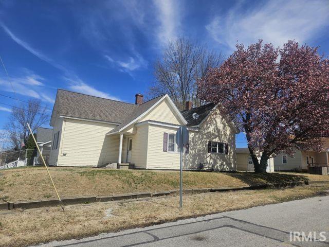view of front of house with a chimney and a front yard